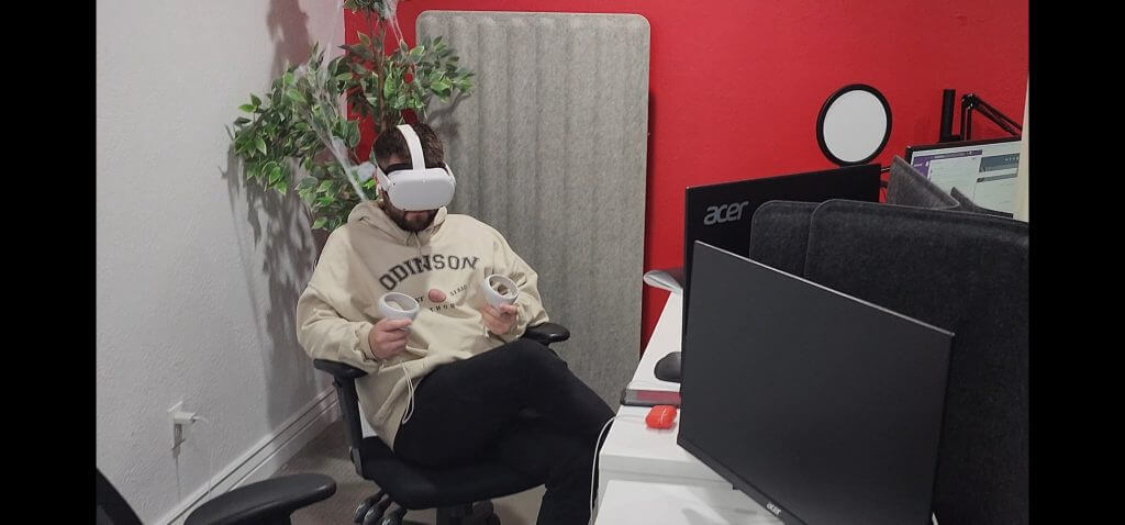 man using a VR headset to work at his desk. 